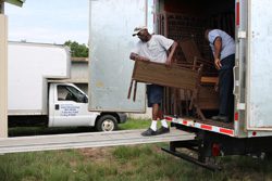 Two men loading a moving truck.