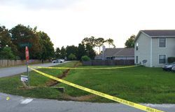 A crime scene with yellow tape in front of a house.