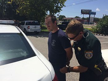 A police officer handcuffing a man.