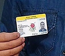 A man holding up an id card with a flower on it.