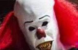 An image of a clown with red hair and a clown mask.