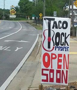 Sign reads: Taco Rock Proper Open Soon