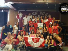 Participants of zumbathon pose for photo with Peruvian flag