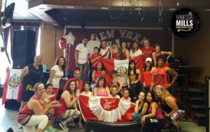 Participants of zumbathon pose for photo with Peruvian flag