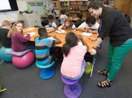 A teacher in a classroom with a group of students.