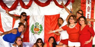 Gropu of women standing next to a Peruvian flag