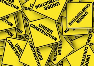 yellow caution signs that say "under construction"