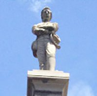 A statue of a man standing on top of a monument.