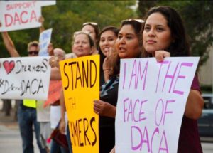women holding signs supporting DACA