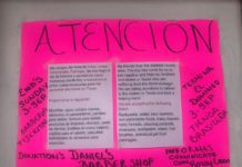 A pink poster with a sign that says attention.