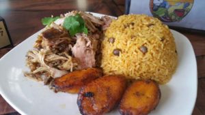 pulled pork, rice and fried plantains on a plate