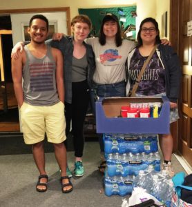 Donors stand with cases of donated water bottles