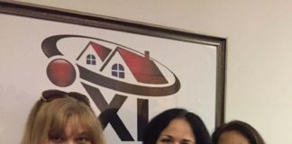 three women standing in front of iXL Real Estate sign