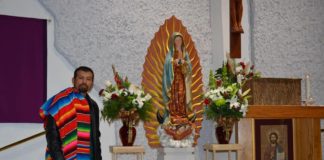 man posing with statue of virgen de guadalupe