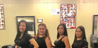 Four women posing for a picture in a hair salon.