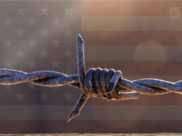 American flag behind barbed wire