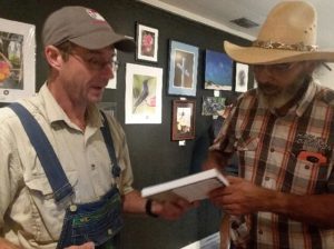 A man hands a book to another man