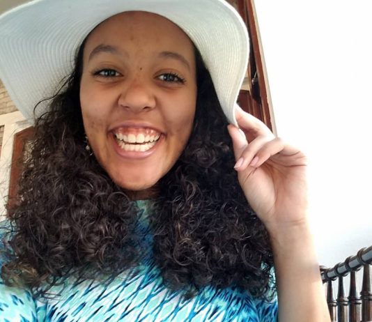 Young woman smiling wearing a floppy hat