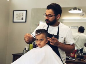 barber cutting boy's hair