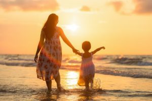 woman and child walking on the beach