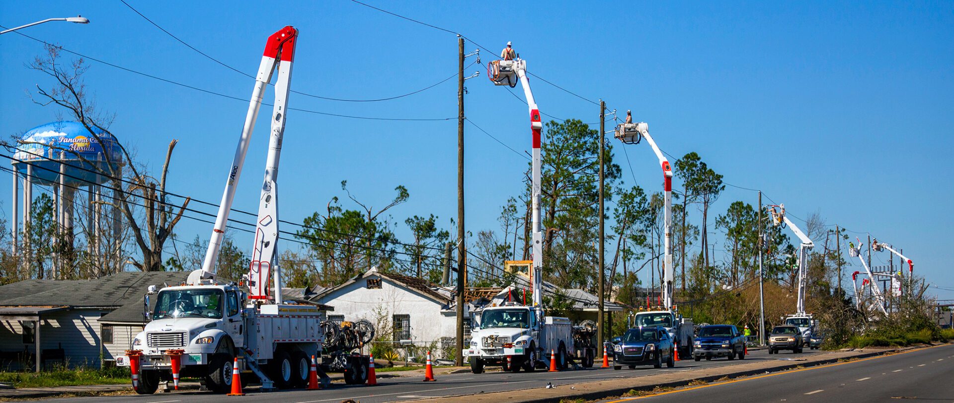 Utility trucks on road with bucket lifts extended