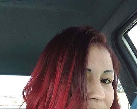 woman with long red hair siting in car