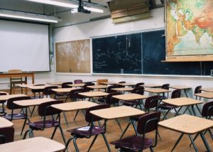 classroom with tables, chairs and blackboard