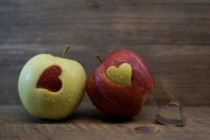 two apples with hearts cut into them