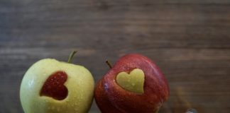 two apples with hearts cut into them