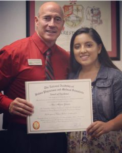 student and administrator presenting certificate