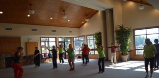 A group of people practicing tai chi in a large room.