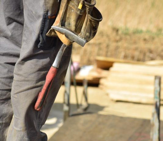 A construction worker holding a tool on a construction site.