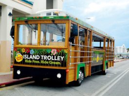 An island trolley is parked in front of a building.