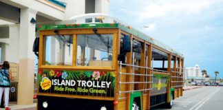 An island trolley is parked in front of a building.