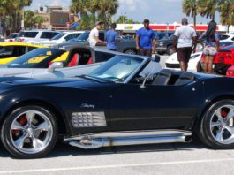 A black corvette parked in a parking lot.