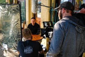 camera crew interviewing someone sitting at a table