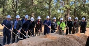 people holding shovels and wearing hardhats