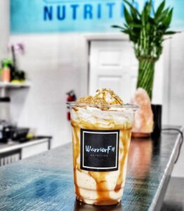 milkshake sitting on a counter with warrior fit logo on the cup