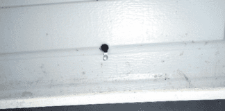 A hole in the side of a garage door.