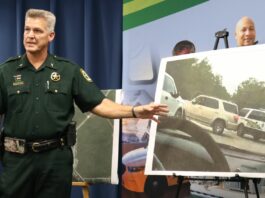 Sheriff pointing at photo of car