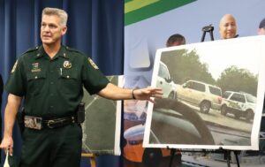 Sheriff pointing at photo of car