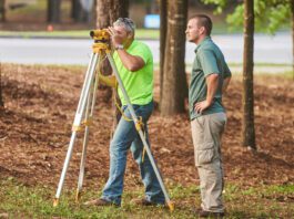 two men using construction surveying equipment