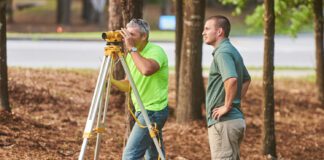 two men using construction surveying equipment
