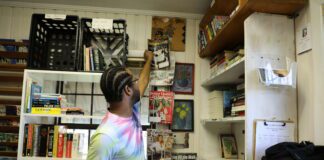 person reaching for a book from shelf
