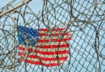 US flag behind fence