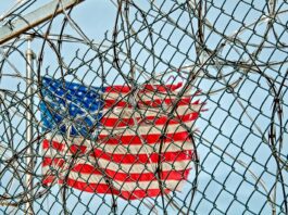 US flag behind fence