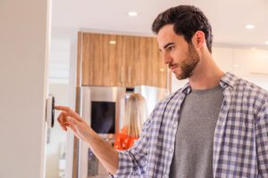 person adjusting a thermostat