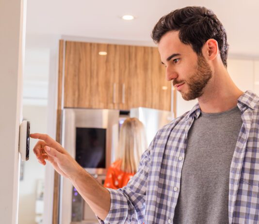 person adjusting a thermostat