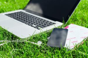 laptop and smart phone on grass