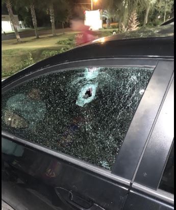 A car with a bullet hole in the window.